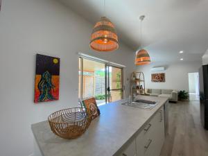 a kitchen with two hanging lights over a counter at Charming Beach Getaway in Valla Beach
