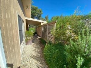 a house with a fence next to a building at Charming Beach Getaway in Valla Beach