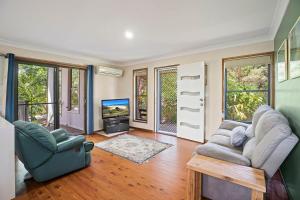 a living room with two couches and a tv at Coastal Charm in Valla Beach
