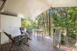a room with a deck with a table and chairs at Coastal Charm in Valla Beach