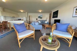 a living room with chairs and a table with a couch at Estuary in Nambucca Heads