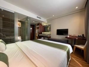 a hotel room with a large bed and a television at CLOVER HOTEL MONIVONG By LEE in Phnom Penh