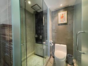 a bathroom with a toilet and a glass shower at CLOVER HOTEL MONIVONG By LEE in Phnom Penh +26 photos