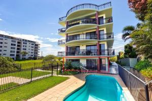 a building with a swimming pool in front of a building at Karingal in Nambucca Heads