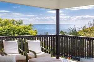 a balcony with chairs and a view of the ocean at 57Charlton in Nambucca Heads
