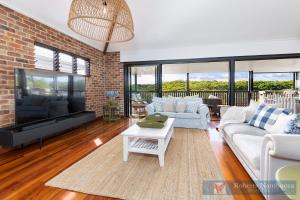 a living room with a couch and a tv at 57Charlton in Nambucca Heads