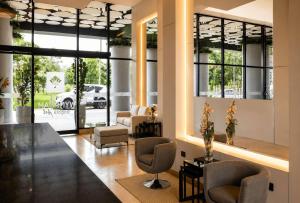 a lobby with chairs and a living room with windows at Wyndham Bogota in Bogotá