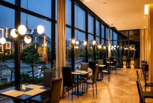 a restaurant with tables and chairs and large windows at Wyndham Bogota in Bogotá +79 photos