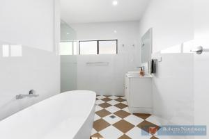 a white bathroom with a toilet and a sink at 57Charlton in Nambucca Heads +19 photos