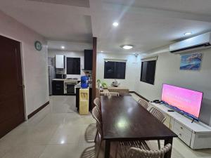 a living room with a table and a large screen tv at Kasa Boutique Residence in Cebu City