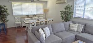 a living room with a couch and a dining room at Riverwood in Nambucca Heads +9 photos