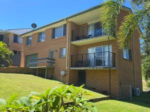 an apartment building with balconies and a yard at Riverwood in Nambucca Heads