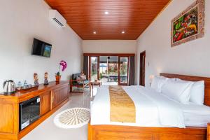 a bedroom with a large bed and a tv at The Siantar Luxury Villa And Spa in Nusa Penida