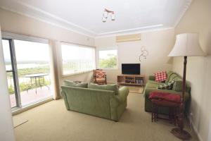 a living room with two couches and a television at The Outlook in Nambucca Heads