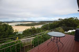 a balcony with a table and a view of a beach at The Outlook in Nambucca Heads