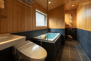 a bathroom with a tub and a toilet and a sink at MR T Kamogawa East 12 in Kyoto