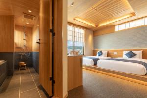 a bedroom with two beds and a bathroom at MR T Kamogawa East 12 in Kyoto