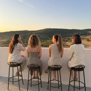a group of women sitting on stools looking at a woman at Under Stars in Nebeur