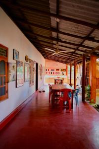 a dining room with a table and chairs in it at Vibushan Guest House in Nilaveli