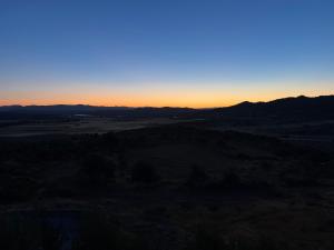 a sunset over a field with mountains in the background at Under Stars in Nebeur