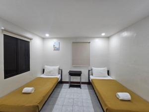 a room with two beds and a table in it at Kasa Boutique Residence in Cebu City +6 photos