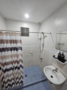 a bathroom with a shower curtain and a sink at Kasa Boutique Residence in Cebu City