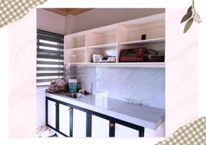 a kitchen with white cabinets and a counter top at MartiVille Residences in Gloria
