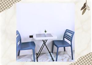 two blue chairs sitting next to a table and a sink at MartiVille Residences in Gloria