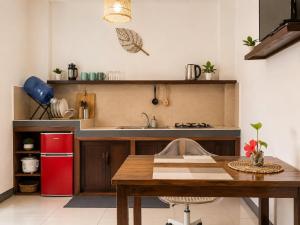 a kitchen with a wooden table and a red refrigerator at Pascoe's Units Siargao- Suites in General Luna