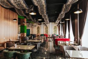 a restaurant with tables and chairs in a room at Leore Hotel in Namangan