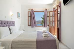 a bedroom with a large bed and a window at Hotel Albatros in Karpathos +109 photos