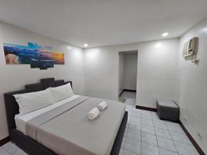 a bedroom with a large bed with two towels on it at Kasa Boutique Residence in Cebu City