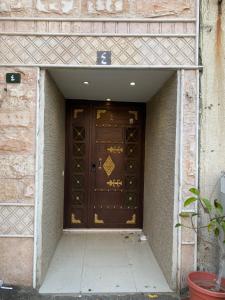 a brown door in a brick building with a sidewalk at كازا in Taif