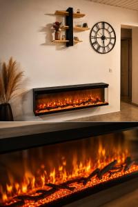 a firecreen fireplace in a living room with a clock on the wall at L'Eden du Piton des Roches in La Plaine des Palmistes