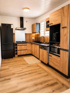 a kitchen with wooden cabinets and a black refrigerator at L'Eden du Piton des Roches in La Plaine des Palmistes +16 photos
