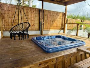 a hot tub on a wooden deck with a chair at L'Eden du Piton des Roches in La Plaine des Palmistes
