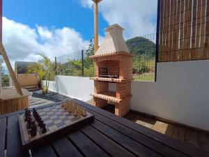a chess board on a wooden table with a fireplace at L'Eden du Piton des Roches in La Plaine des Palmistes