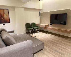 a living room with a couch and a flat screen tv at Hamsun DHA in Karachi