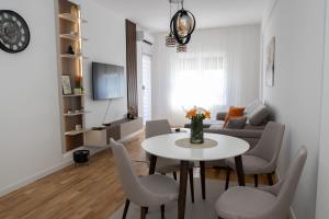 a living room with a table and chairs and a couch at Apartman Solis in Trebinje
