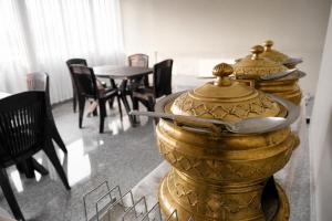 a gold container with a spoon on it next to a table at Vilasa Prime Hotel in Guwahati