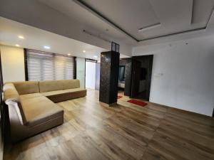a living room with a couch and wooden floors at Forest edge Villa - 3 bedrooms in Ambalavayal