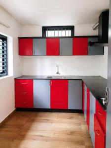 a kitchen with red and white cabinets and a sink at Forest edge Villa - 3 bedrooms in Ambalavayal