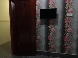 a wall with flowers on it with a television at Unique Hotel in Phnom Penh