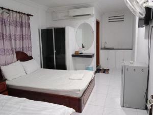 a small bedroom with two beds and a mirror at Unique Hotel in Phnom Penh