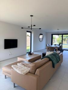 a living room with a couch and a tv at Ten Zilte in Blankenberge