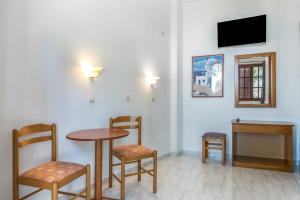 a room with a table and two chairs and a tv at Hotel Albatros in Karpathos