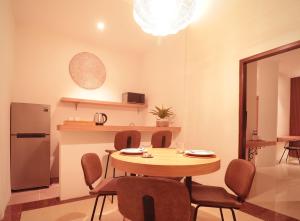 a dining room with a table and chairs and a refrigerator at Amaya Residence Jimbaran in Jimbaran