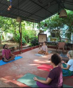 a group of people sitting in a yoga class at iha ayurveda resort in Varkala