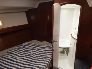 a small bedroom with a blue and white striped bed at Puerto Calero Boat in Puerto Calero