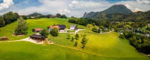 an aerial view of a house on a green field at Stadtbauernhof Salzburg - Ferienwohnung - Gut Unterleithen - farm & the city in Salzburg